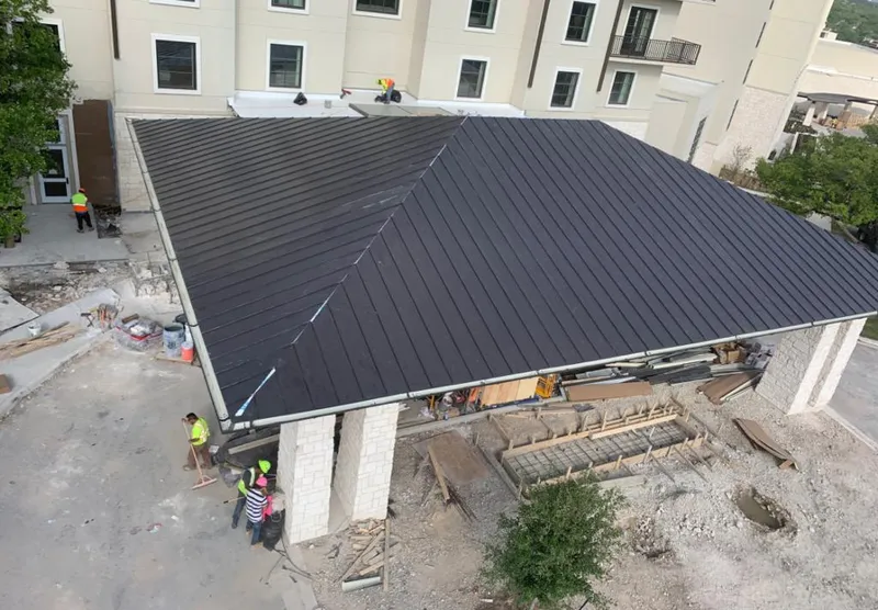 Metal roofing installation team working on a commercial building in Gary